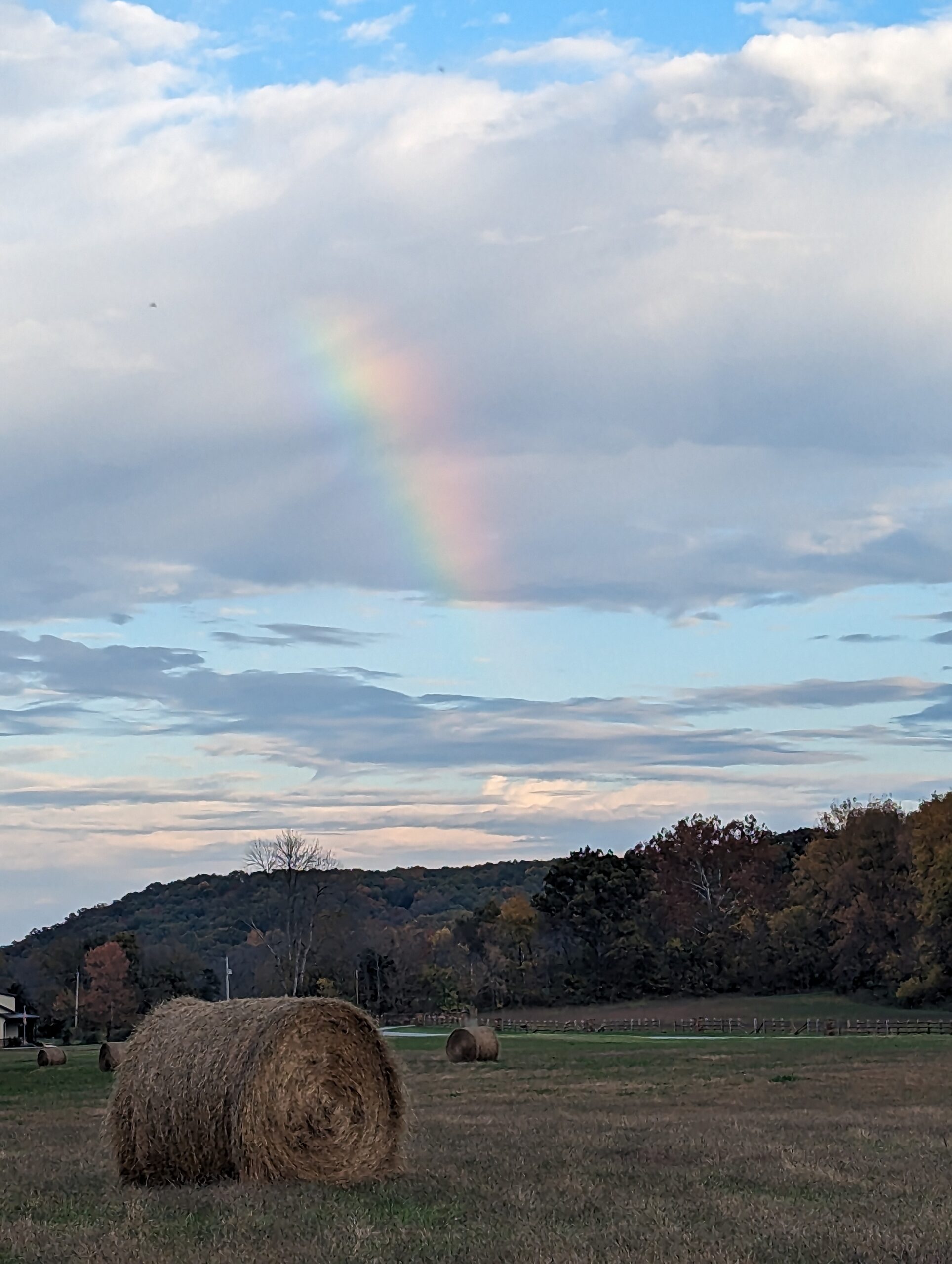 Rainbow over hay bale at Faith Family Farms
