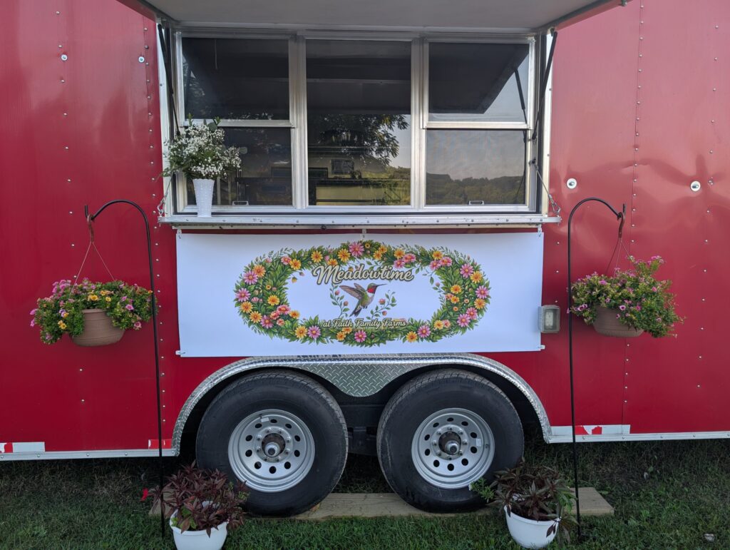 The Meadowtime at Faith Family Farms trailer with hanging flower baskets