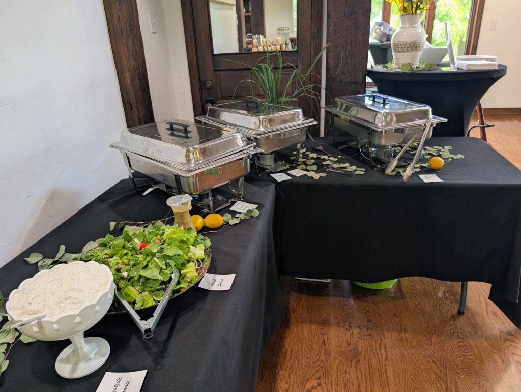 Catered buffet with chafing dishes, Greek salad, and tzatziki
