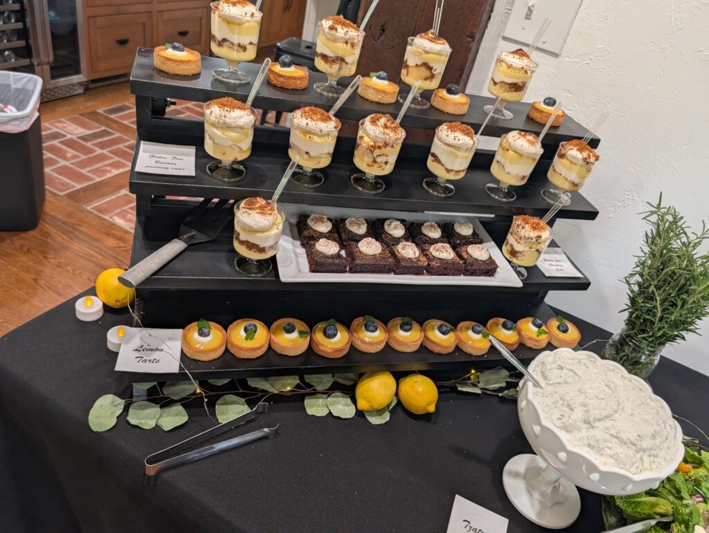 Dessert display with lemon tarts, gluten-free banana pudding cups, and gluten-free chocolate cake